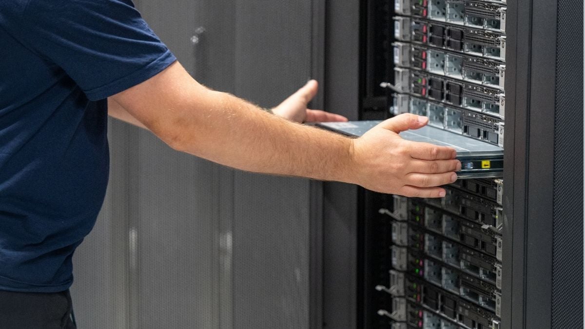 A server engineer inserts back the bare metal server to the rack